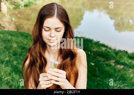 Woman holding a spring flower in her hand in sunlight, conservation and ecology Stock Photo