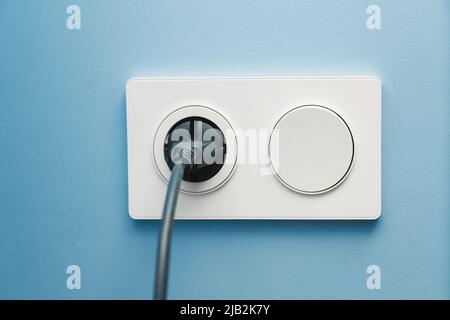 Integrated switch with socket. electric socket with plug cord and a switch on the wall Stock Photo