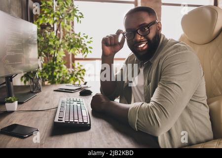 Profile side view portrait of attractive cheery guy director tech leader touching specs at workplace workstation indoors Stock Photo