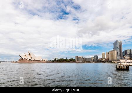 Sydney City, Australia - April 16, 2022: Sydney Opera House and Circular Quay viewed through Campbells Cove from Hickson Road Reserve on a day Stock Photo