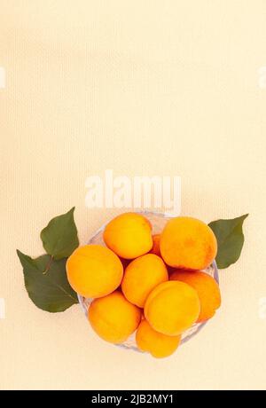 Ripe juicy summer apricots in a transparent plate close-up. Stock Photo