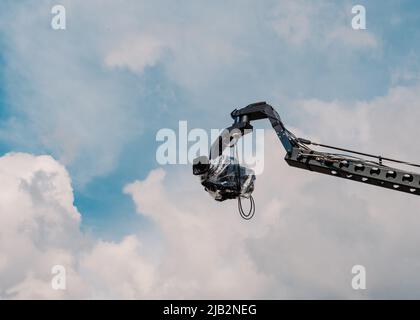 Professional camera mounted on a crane. Organization of video shooting. The camera is mounted at a height. Professional videography of the event. Stock Photo