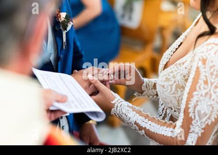 Close-up view of a bride puts a ring on the groom finger at the wedding ceremony. Stock Photo