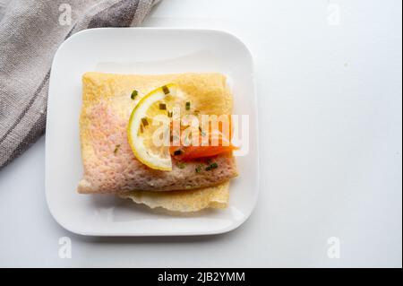 Cuisine of Normandy, galette pancake filled with goat cheese and smoked salmon served with fresh lemon, France Stock Photo