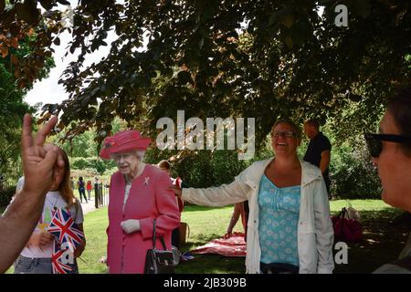 London, UK. 2nd June, 2022. A woman with a cardboard of the Queen in Hyde Park. Thousands of people have turned out in central London as celebrations begin for the Queen's Platinum Jubilee, an unprecedented event in British history (Credit Image: © Laura Chiesa/Pacific Press via ZUMA Press Wire) Credit: ZUMA Press, Inc./Alamy Live News Stock Photo