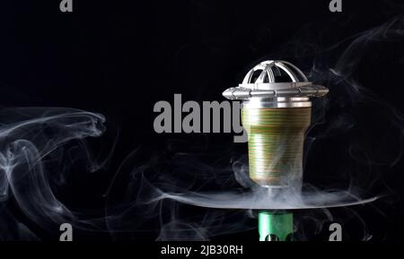 Hookah bowl on a black background with smoke. space for text Stock Photo