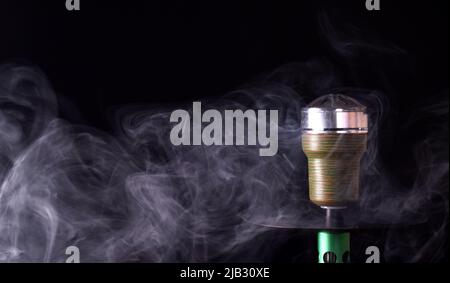 Hookah bowl on a black background with smoke. space for text Stock Photo