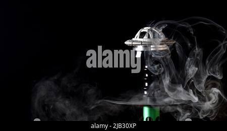 Hookah bowl on a black background with smoke. space for text Stock Photo