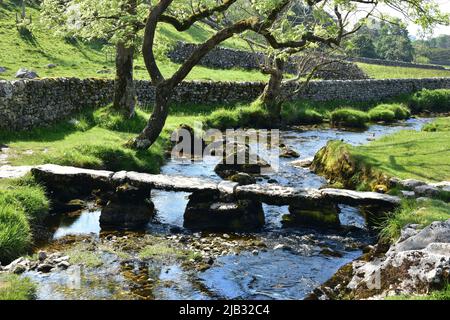 Malham Cove, clapper bridge over Malham beck, Malham, Yorkshire Dales in Summer Stock Photo