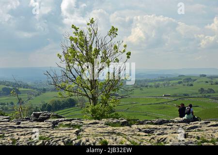 Malham Cove, couple looking at view from the top, Malham, Yorkshire Dales in Summer Stock Photo