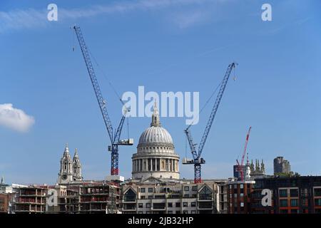 St Paul's Cathedral surrounded by two construction cranes on a clear sunny day. Stock Photo