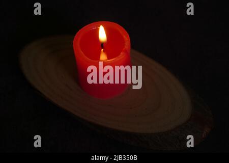One light candle burning brightly in the black background Stock Photo