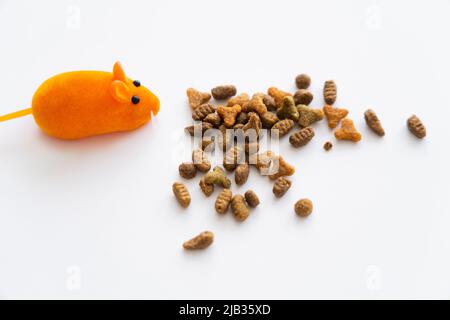top view of dry cat food near orange rubber mouse isolated on white Stock Photo