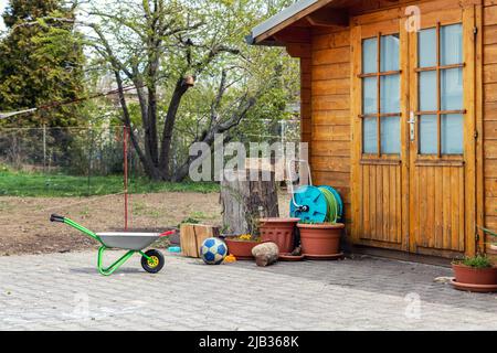 Small beautiful wooden house shed or storage hut for garden tools equipment and bicycles at backyard at beautiful american or european countryside Stock Photo