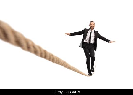 Businessman walking on a tightrope and smiling isolated on white background Stock Photo