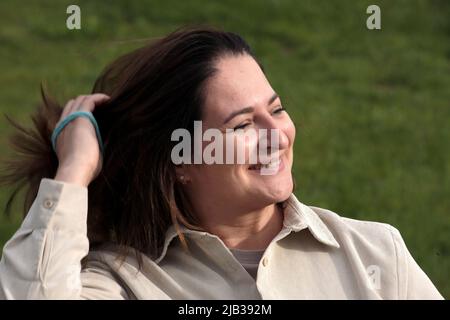 Happy woman near the forest in nature in warm clothes at sunset Stock Photo