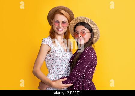 smiling mother and child in straw hat on yellow background Stock Photo