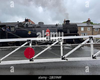 Steam Locomotice passing through Level Crossing at Grosmont Train Station Stock Photo