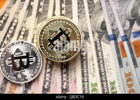 Piled up bitcoin coins on top of US dollar banknotes. Gold and silver BTC coins. Crypto exchange to US dollar concept. Digital crypto currency with pa Stock Photo