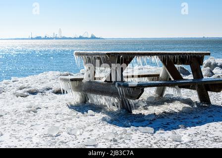 Ice Cycles on picknic table near Lake Erie with Cedar Point Amusement Park in the Distance Stock Photo