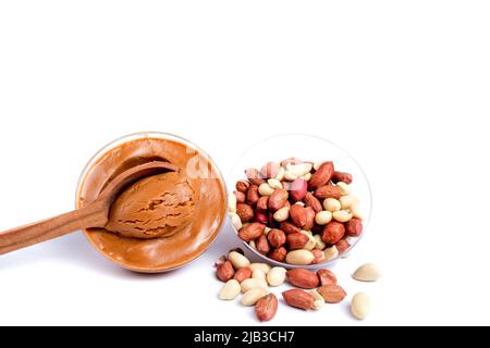 Peanuts with peanut paste in a wooden spoon. Isolated on a white background Stock Photo