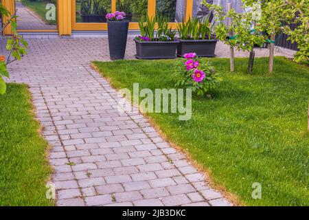 Beautiful view of garden with flower beds sprouting gladiolus, hydrangeas and other flowers. Sweden. Stock Photo