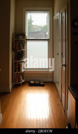 Morning sunlight coming in through blinds in kitchen hallway Stock Photo