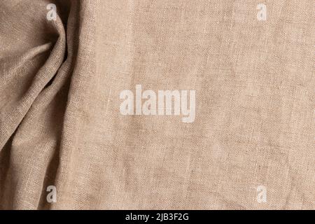 Texture old brown linen canvas fabric. Natural organic eco textiles burlap, grungy rustic cloth material background. Crumpled wrinkled material. Top Stock Photo
