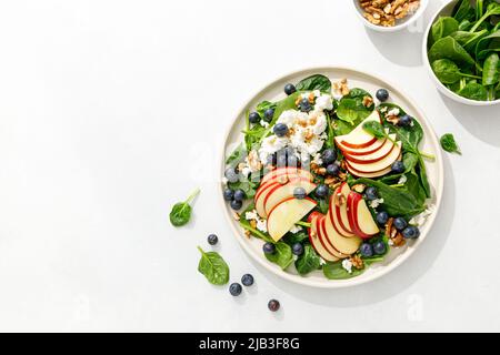 Apple and spinach fresh sweet fruit salad with blueberry, cheese cottage and walnuts, top view Stock Photo