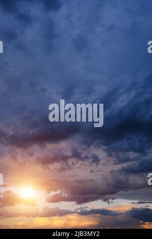 Thunderclouds with breaking rays sun at sunset Stock Photo