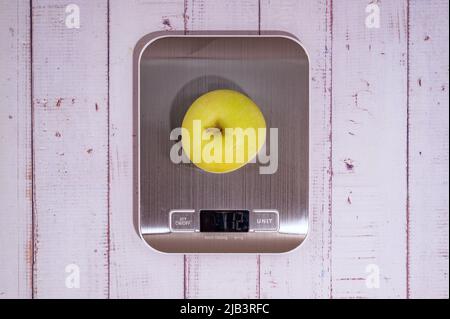 https://l450v.alamy.com/450v/2jb3rfc/an-apple-lies-on-a-digital-kitchen-scale-on-a-table-of-light-boards-top-view-2jb3rfc.jpg