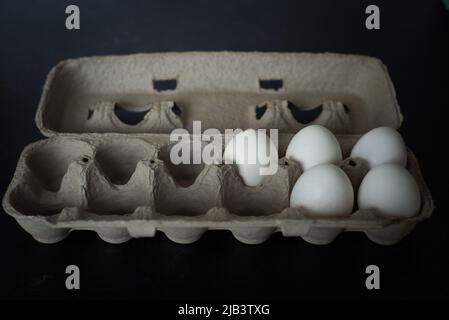 Carton of fresh white eggs on dark background. Stock Photo