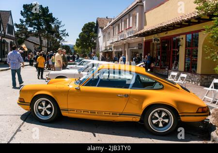 Spectators enjoy classic cars in downtown Carmel, seen at the Carmel-by-the-Sea Concours on the Avenue event during Monterey Car Week Stock Photo