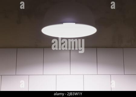 White lamp on a minimalist tile wall background Stock Photo