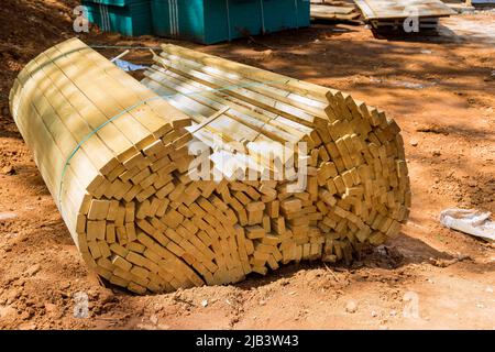 Stack of unloading wooden beams on construction building from beam construction materials Stock Photo
