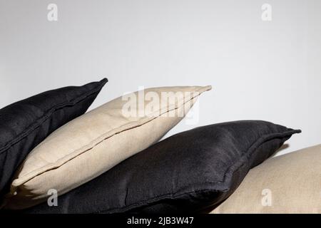 Black and brown pillows on the bed on a gray background. Modern interior design Stock Photo
