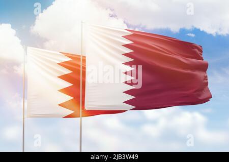 Sunny blue sky and flags of qatar and bahrain Stock Photo