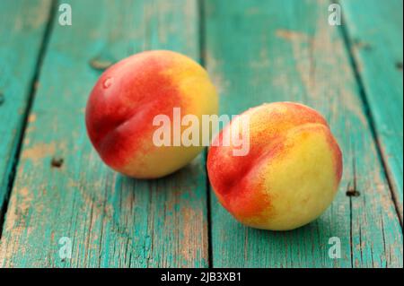 Two fresh ripe whole nectarines on vintage turquoise table closeup Stock Photo