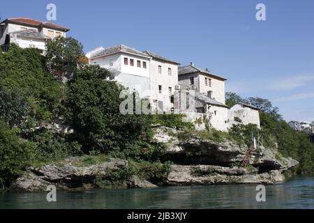 A view of the ancient city of Mostar, Bosnia with it's old town, riverside buildings taken from the old Bridge over Neretva River. Stock Photo