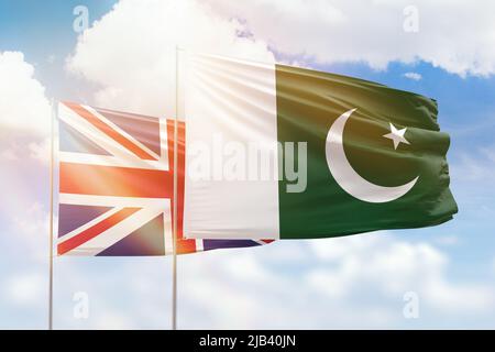 Sunny blue sky and flags of pakistan and united kingdom Stock Photo