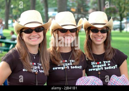 three sisters triplets with cowboy hats and smiles Stock Photo