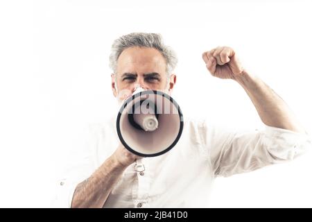 Middle-aged caucasian male protester is angry, loudly shouts via loudspeaker, and throws his fist in the air. Isolated over white background. High quality photo Stock Photo