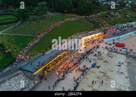 Lyme Regis, Dorset, UK.  2nd June 2022.  Torchlight parade and beacon lighting at Lyme Regis in Dorset to celebrate the Queen’s Platinum Jubilee.   View of the torchlight parade from the air as it makes its way to the beach from Langmoor and Lister Gardens.  Picture Credit: Graham Hunt/Alamy Live News Stock Photo