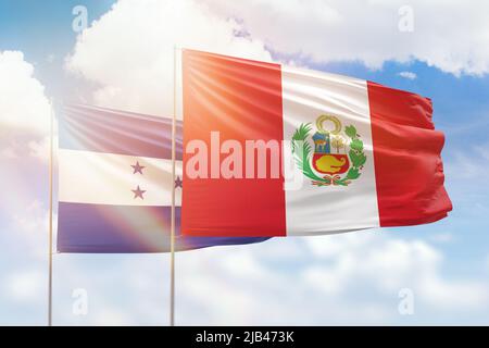 Sunny blue sky and flags of peru and honduras Stock Photo