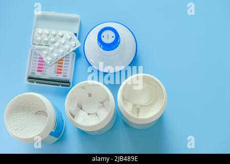 Water quality check. Pool cleaning set.Water cleaner . Chlorine tablets,blue plastic filter, ph tests for water Stock Photo
