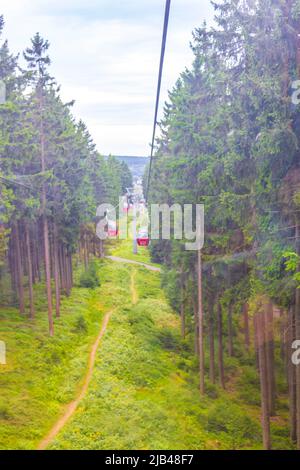 Wurmberg ride with the red gondola cable car railway with panorama view to mountain landscape of Braunlage Harz Goslar in Lower Saxony Germany.