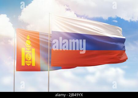 Mongolia and Russia flags waving together in the wind on blue cloudy ...