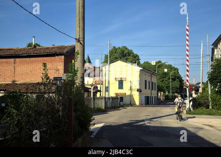 Man on a bike next to a railroad crossing Stock Photo