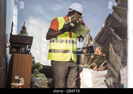 Mark Oluoch an electronic waste worker with Waste Electrical and Electronic Equipment Centre (WEEE Centre) sorts electronic waste at an e-waste collection center in Nakuru before it is later transported to Nairobi for recycling. Kenya generates about 11,000 metric tonnes of electronic waste every year, most of this waste has been found to contain harmful chemicals like lead, mercury, and phosphorus. There are calls to increase collection and recycling rates for both electronic and plastic waste to safeguard the environment and public health. Stock Photo