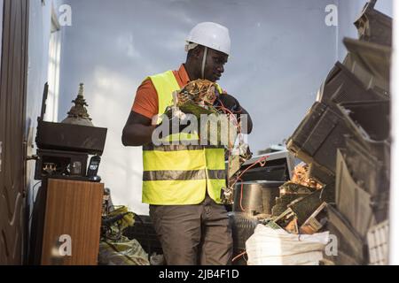 Mark Oluoch an electronic waste worker with Waste Electrical and Electronic Equipment Centre (WEEE Centre) sorts electronic waste at an e-waste collection center in Nakuru before it is later transported to Nairobi for recycling. Kenya generates about 11,000 metric tonnes of electronic waste every year, most of this waste has been found to contain harmful chemicals like lead, mercury, and phosphorus. There are calls to increase collection and recycling rates for both electronic and plastic waste to safeguard the environment and public health. Stock Photo